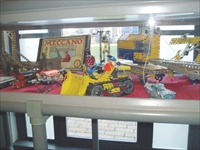 A picture of a Meccano Bulldozer with surrounding models including a steam engine, Breakdown crane and a small tugboat. Also a rare Inventors A set